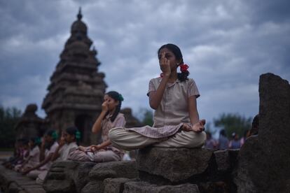 Un grupo de alumnas participa en una sesión de yoga en el Templo de la Orilla, construido entre los años 700 y 728, a los pies de la bahía de Bengala, en la ciudad india de Mahabalipuram, para celebrar el Día Internacional de esta disciplina.