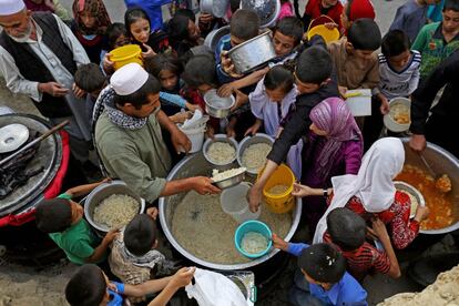 Aldeões afegãos recebem comida para romper o jejum durante o mês sagrado do Ramadã em Cabul, em 3 de julho de 2014.