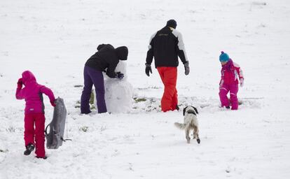 Una familia disfruta de la nieve caída en Piedrafita do Cebreiro, en Lugo, el 4 de marzo de 2017. La nieve caída en las últimas horas obliga a circular con cadenas o neumáticos de invierno en varios puntos de la península.