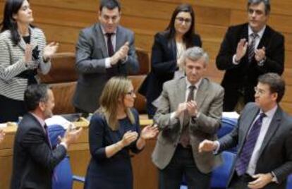La conselleira de Hacienda, Elena Muñoz (c) recibe el aplauso del presidente, Alberto Núñez Feijóo (d) y del grupo popular, tras aprobar el pleno del Parlamento de Galicia, el presupuesto para el próximo año.