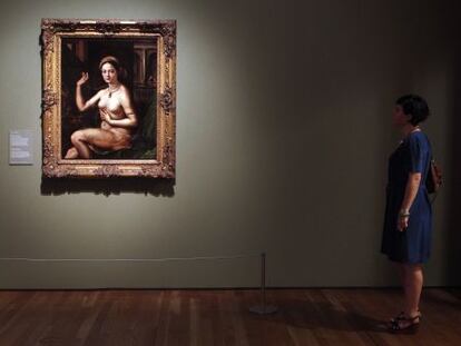 Una mujer contempla una 'Mujer ante el espejo', de Giulio Romano, discípulo de Rafael, en la exposición del Museo del Prado
