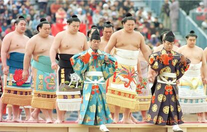 Luchadores de sumo abandonan el escenario tras realizar un ritual típico japonés para expulsar los espíritus demoníacos en la ceremonia de inauguración de los Juegos Olímpicos de Invierno 1998, que se celebraron en Nagano (Japón)