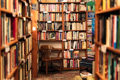 Una silla rodeada de estanterías con libros.