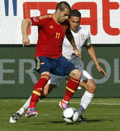 El delantero sevillista Álvaro Negredo protege el balón ante el defensa de Serbia Dusko Tosic.