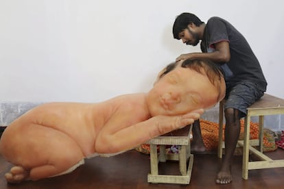 El artista indio Samar Barik trabaja en la figura de un bebé que formará parte de una instalación artística en el festival 'Durga Puja', en Calcuta (India).