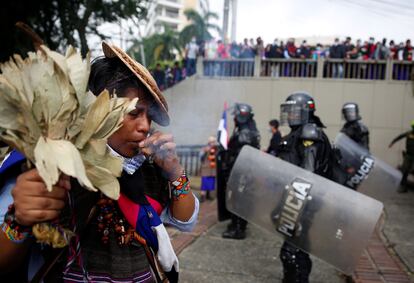 Un indígena lleva a cabo un ritual junto a las autoridades que tratan de dispersar a manifestantes en Cali, el pasado 28 de abril.