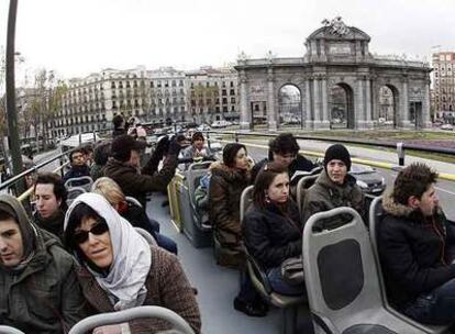 Varios visitantes recorren las calles de la capital sobre un autobús turístico.