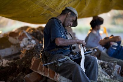 A member of the self defense forces of Michocán cleans his weapon.