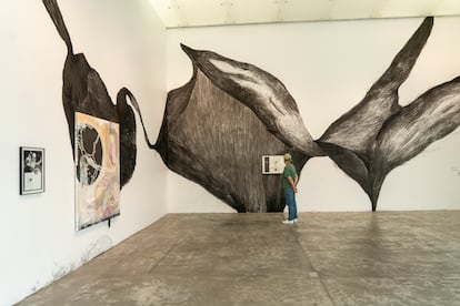 Una persona observa el mural 'La piel son nubarrones negros'.
