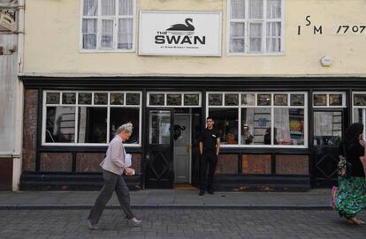 Una mujer pasa junto al pub Swan pub en Ipswich, Inglaterra. 