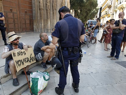 Un agente, junto a varios indignados ayer en la plaza del Ayuntamiento de Valencia.