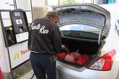 Jorge Ortiz, habitante del distrito de Carolina, al este de San Juan, llena unos tanques con gasolina para abastecer un generador eléctrico casero.