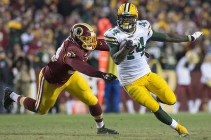 El running back de los Green Bay Packers James Starks escapa con el balón ante Preston Smith de los Redskins.