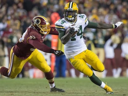 El running back de los Green Bay Packers James Starks escapa con el balón ante Preston Smith de los Redskins.