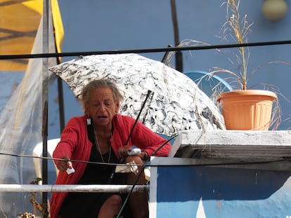 La activista Amparo Carvajal trepa por una escalera de mano hasta la terraza de la Asamblea Permanente de los Derechos Humanos de Bolivia, en La Paz.