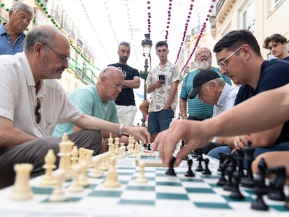 Jose Antonio Sánchez (camiseta verde) organiza partidas de ajedrez entre jugadores en los bancos de la calle Larios, en Málaga.