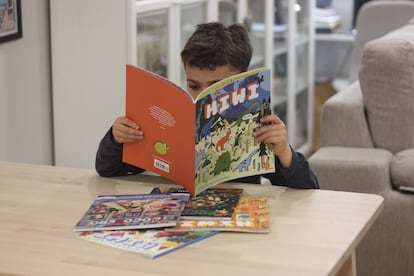 Un niño lee con interés 'Kiwi', revista infantil.