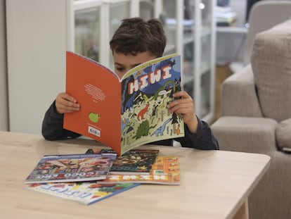Un niño lee con interés 'Kiwi', revista infantil.