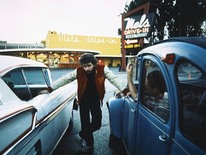 George Lucas poses between two cars during the filming of ‘American Graffiti’ in San Francisco in 1973.