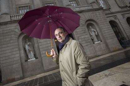 Jaume Ciurana es protegeix de la pluja a la porta de l&rsquo;Ajuntament de Barcelona. 