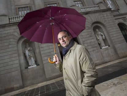 Jaume Ciurana es protegeix de la pluja a la porta de l&rsquo;Ajuntament de Barcelona. 