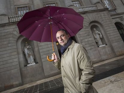 Jaume Ciurana es protegeix de la pluja a la porta de l&rsquo;Ajuntament de Barcelona. 