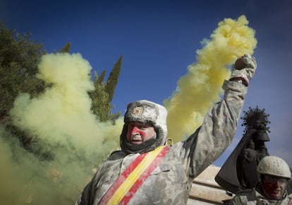 Un hombre cubierto de harina sostiene una bomba de humo durante la celebración de la fiesta 'els enfarinats' en Ibi.