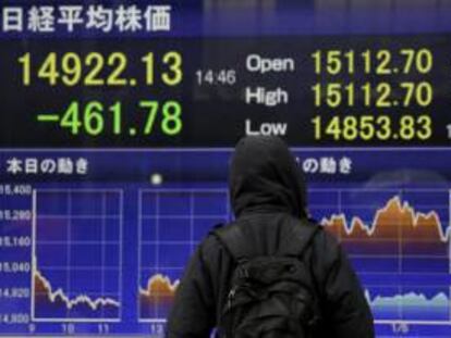 Un peatón se detiene ante una pantalla con los resultados de la Bolsa de Tokio, en Japón.