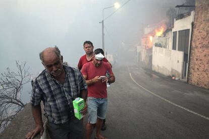 Personas en la calle mientras el incendio se acerca a las casas en Born Sucesso, isla de Madeira.