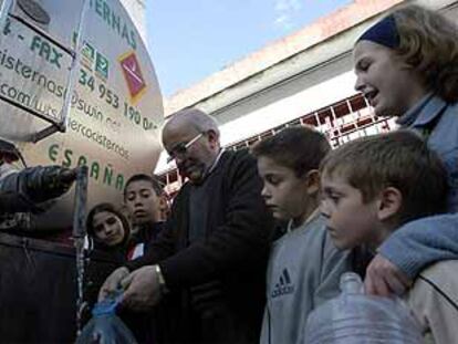 Un hombre se aprovisiona de agua en un camión cisterna