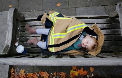 Un bebé de 18 meses duerme en un banco situado en el exterior del Parlamento británico durante una protesta del Cuerpo de Bomberos en Londres (reino Unido), el 2 de noviembre de 2015.