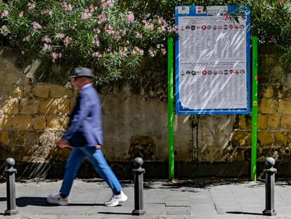 Un hombre pasea frente a un cartel con las listas electorales europeas en Nápoles.