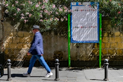 Un hombre pasea frente a un cartel con las listas electorales europeas en Nápoles.