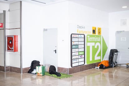 Una persona duerme en los pasillos que conectan la terminal 1 y 2 de Barajas durante la madrugada del lunes. 