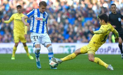 Martin Odegaard (I) y Manuel Trigueros se disputan el balón.