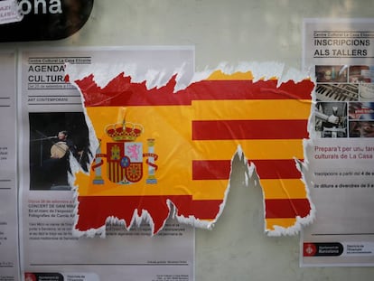 Una pegatina dañada con una bandera española y una senyera.