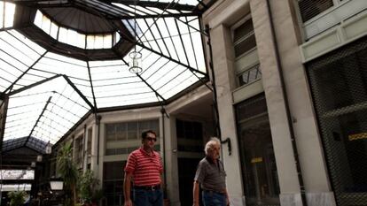 Dos hombres caminan por un centro comercial en Atenas.