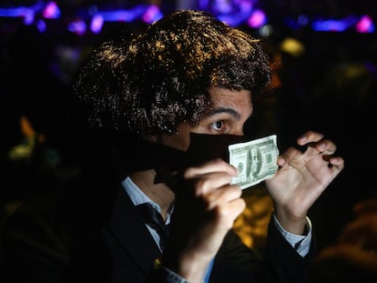 A Milei supporter holds up a $100 bill, at the candidate’s final rally before the first round of the presidential election, on October 18, 2023.