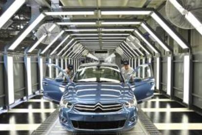 Varios empleados trabajan en una factoría del grupo francés PSA Peugeot Citroen. EFE/Archivo