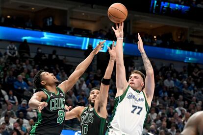 Luka Doncic lanza mientras Josh Richardson y Jayson Tatum intentan impedirlo.