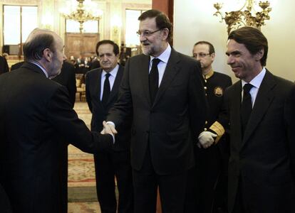 El presidente del Gobierno, Mariano Rajoy, junto al expresidente José María Aznar, saluda al secretario general del PSOE, Alfredo Pérez Rubalcaba, a su llegada al Congreso de los Diputados, donde ha sido instalada la capilla ardiente del expresidente del Gobierno Adolfo Suárez, en el Salón de los Pasos Perdidos de la Cámara Baja.