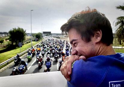 Dani Pedrosa, campen del mundo de motociclismo en la categora de 250cc, muestra su alegra montado en un autobs de dos pisos, seguido por una multitud de aficionados en moto, en Barcelona.