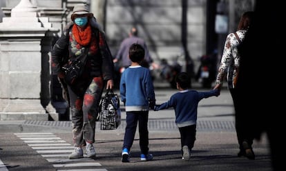 Un par de niños cruzan de la mano de su madre una calle en Madrid el 17 de marzo. 