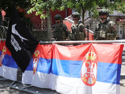 Soldados de la misión de paz de la OTAN en Kosovo (Kfor) protegen el Ayuntamiento de Zvecan, detrás de una barrera con banderas de Serbia y otra negra donde se lee en inglés: "Solo protesta, sin violencia", el 29 de junio.