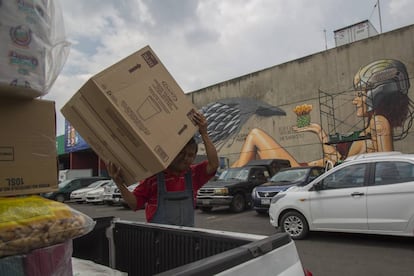 Un trabajador de la Central de Abasto durante su jornada laboral frente de uno de los nuevos murales.