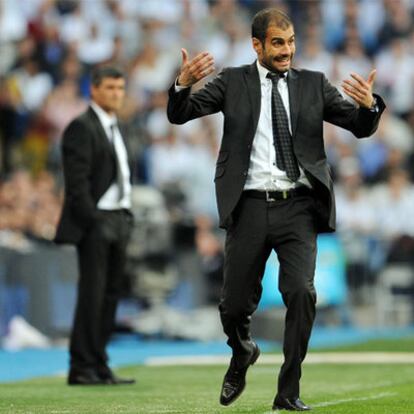 Guardiola, con Juande al fondo, da instrucciones a sus jugadores durante el partido.