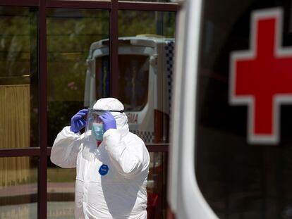 Personal sanitario llega al Centro de Acogida, Emergencia y Derivación de Cruz Roja de Málaga para trasladar a una de las personas afectadas por la covid-19 al hospital.