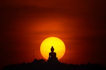 Pôr do sol e uma estátua de Buda em Phuket (Tailândia), em 18 de março de 2016.