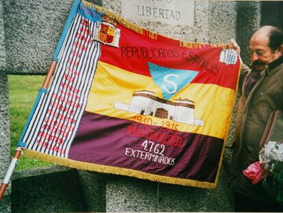 Enric Marco en 2003, cuando presidía la asociación Amical de Mauthausen, junto a una bandera alusiva a los exterminios nazis.