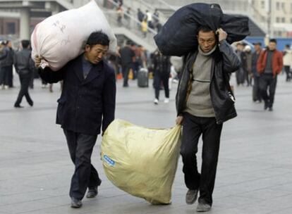 Dos trabajadores salen de la estacin de tren de Pekn (China).